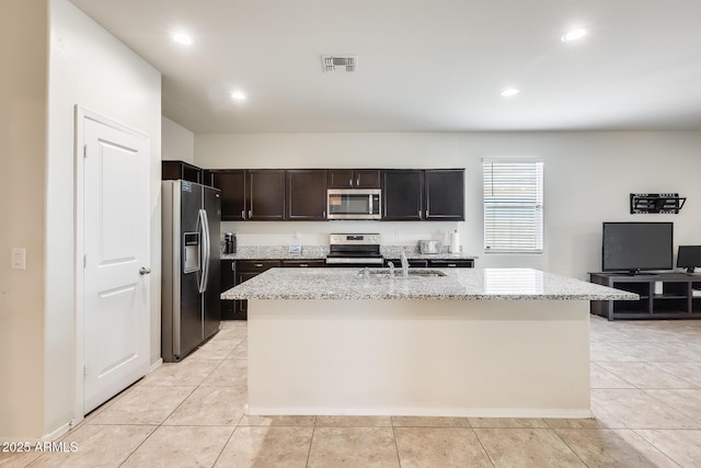 1718 W Cameron Blvd, Coolidge, AZ 85128 - kitchen with appliances with stainless steel finishes, light stone counters, a center island with sink, a sink, and recessed lighting
