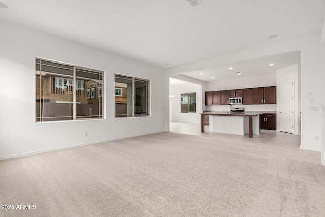 unfurnished living room with visible vents, recessed lighting, light colored carpet, and baseboards