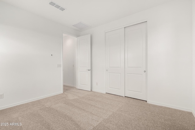 unfurnished bedroom featuring visible vents, light carpet, and baseboards