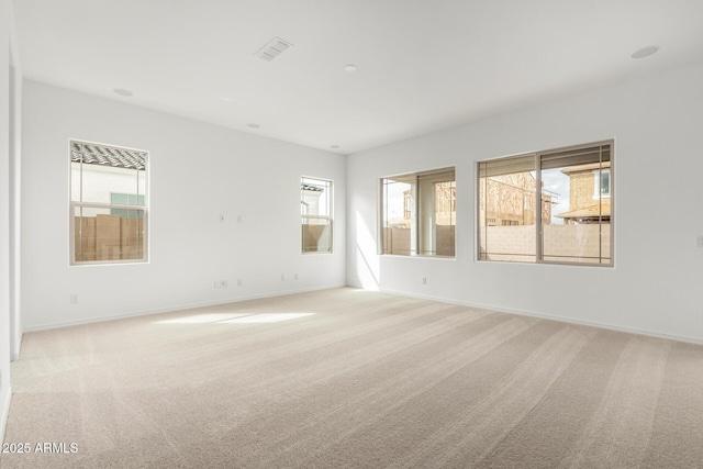 unfurnished room featuring light colored carpet and baseboards