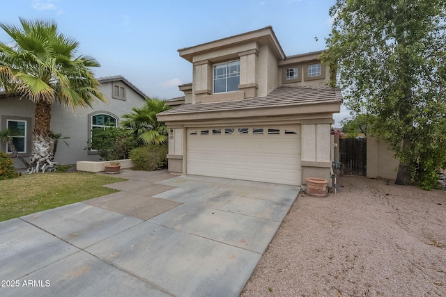 traditional-style house featuring stucco siding, a garage, concrete driveway, a tile roof, and fence