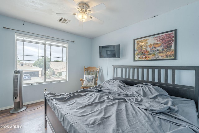 bedroom with wood finished floors, baseboards, a ceiling fan, and lofted ceiling
