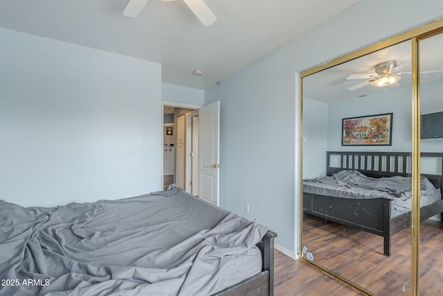 bedroom featuring wood finished floors, a ceiling fan, and a closet