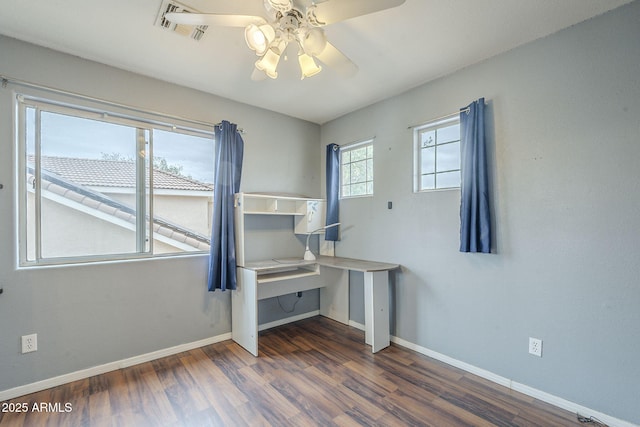 unfurnished bedroom with wood finished floors, baseboards, a desk, and a ceiling fan