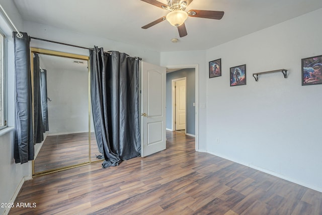unfurnished room featuring wood finished floors, baseboards, and a ceiling fan