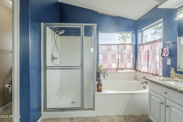 full bathroom with a shower stall, vanity, vaulted ceiling, and a garden tub