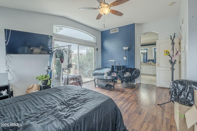 bedroom featuring arched walkways, wood finished floors, access to exterior, connected bathroom, and ceiling fan
