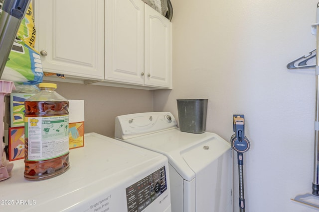washroom featuring washer and clothes dryer and cabinet space