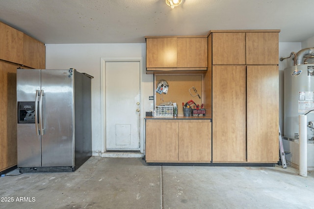 kitchen with stainless steel fridge, unfinished concrete floors, and gas water heater