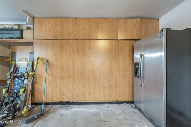 kitchen with stainless steel fridge, unfinished concrete flooring, and open shelves