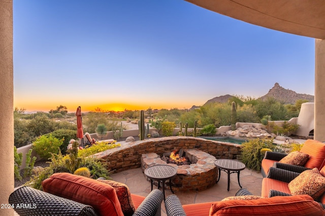 patio terrace at dusk with a mountain view and an outdoor fire pit