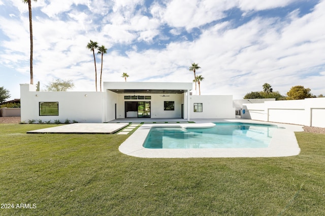 rear view of house featuring a fenced in pool, a patio, ceiling fan, and a lawn