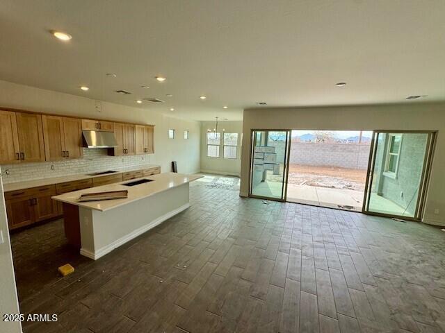 10039 W Verde Ln, Avondale, AZ 85392 - kitchen featuring dark wood finished floors, tasteful backsplash, under cabinet range hood, and black stovetop