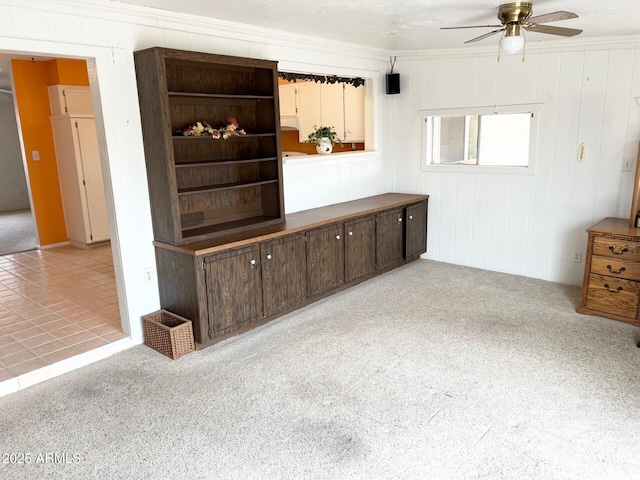 interior space with a ceiling fan and crown molding