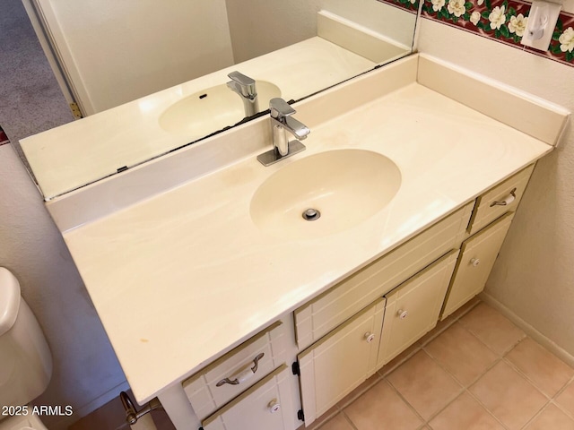 bathroom with tile patterned flooring, vanity, and toilet