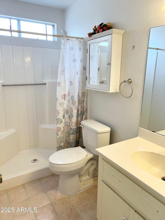 bathroom with toilet, a stall shower, a textured wall, and vanity