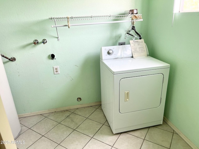 washroom with washer / clothes dryer, light tile patterned flooring, baseboards, and laundry area