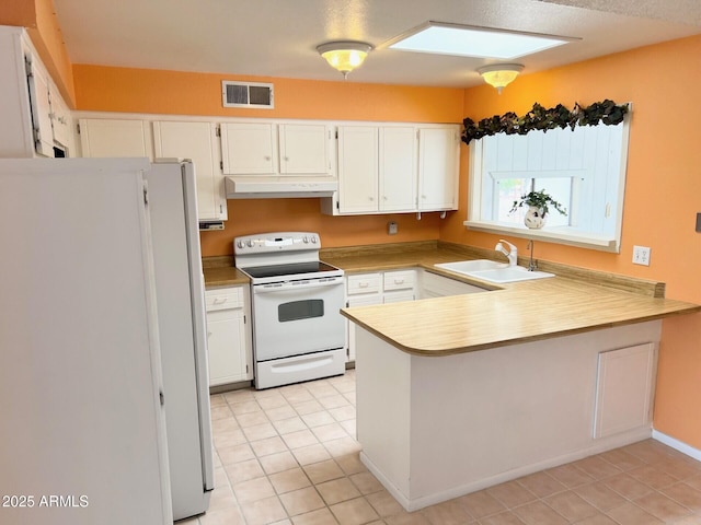 kitchen with visible vents, a sink, a peninsula, white appliances, and under cabinet range hood