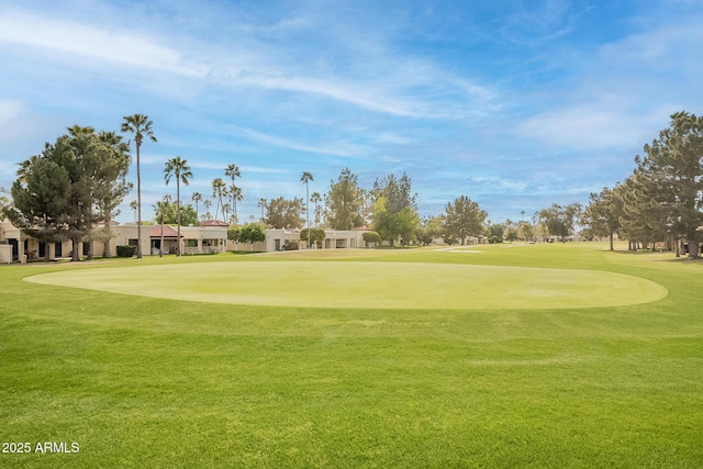 view of community with view of golf course and a lawn