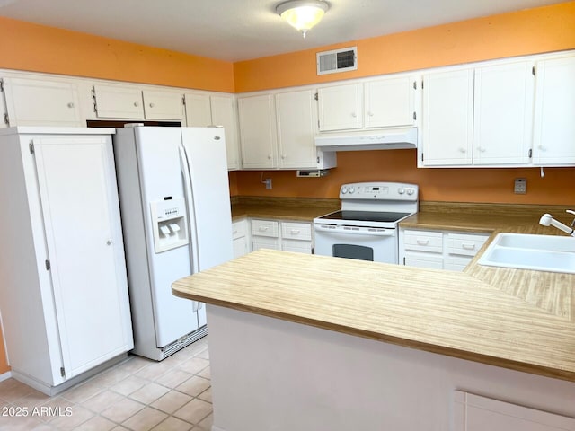 kitchen with under cabinet range hood, a peninsula, white appliances, a sink, and visible vents