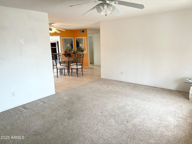 spare room with light carpet, visible vents, and a textured ceiling