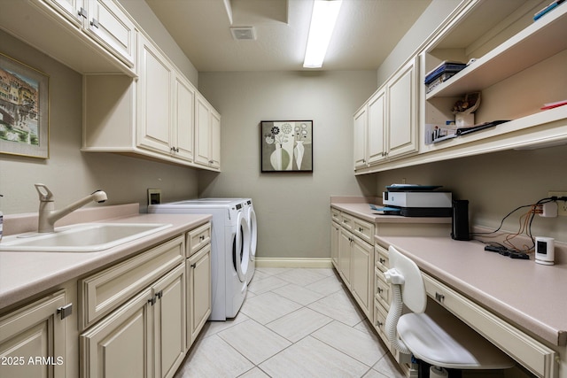 laundry area featuring cabinet space, baseboards, visible vents, washer and clothes dryer, and a sink