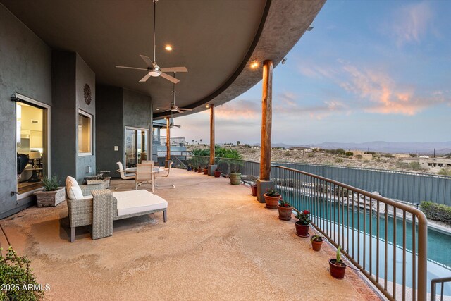 patio terrace at dusk featuring ceiling fan