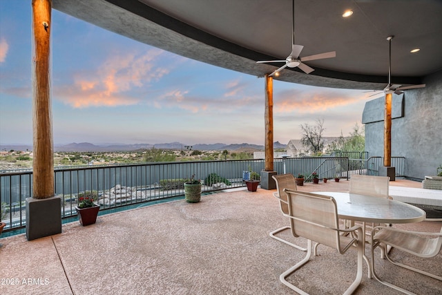 view of patio / terrace featuring a mountain view, a ceiling fan, and outdoor dining space