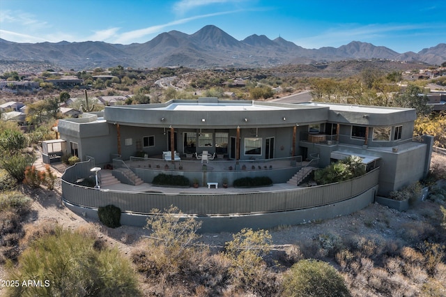 back of property with stairway, fence, and a mountain view