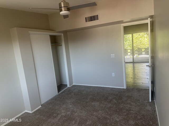 unfurnished bedroom with dark carpet and a closet