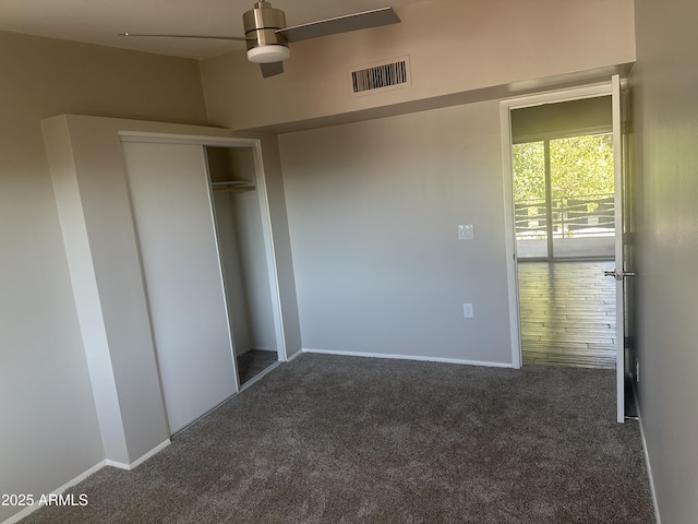 unfurnished bedroom with dark carpet and a closet