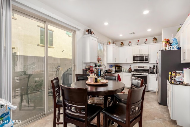 kitchen with white cabinets, light tile patterned flooring, and appliances with stainless steel finishes