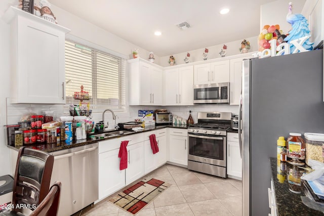 kitchen with sink, white cabinets, dark stone counters, and appliances with stainless steel finishes