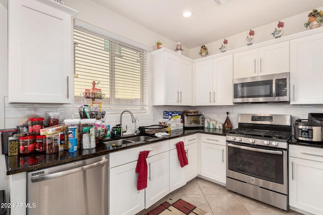 kitchen featuring white cabinets, decorative backsplash, sink, and stainless steel appliances