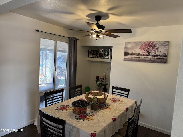 dining room featuring baseboards, a ceiling fan, and dark wood-style flooring