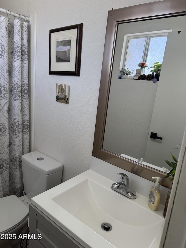 bathroom featuring toilet, a shower with curtain, and vanity