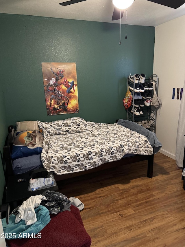 bedroom with baseboards, wood finished floors, and ceiling fan