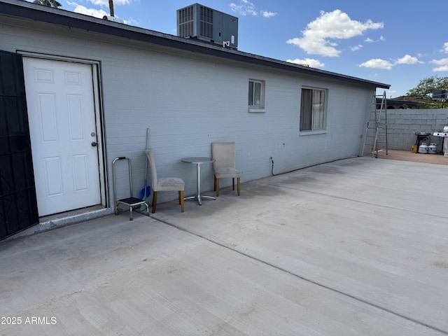 rear view of property featuring a patio, central air condition unit, and fence