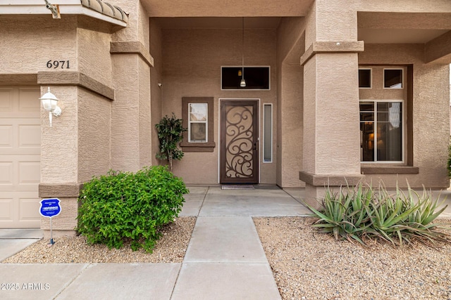6971 W El Cortez Pl, Peoria, AZ 85383 - view of exterior entry featuring a garage and stucco siding