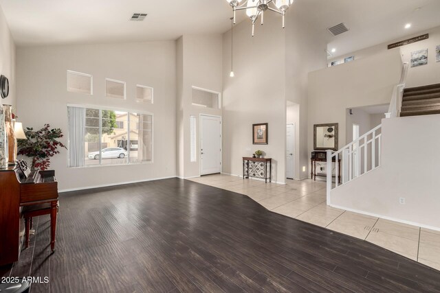 6971 W El Cortez Pl, Peoria, AZ 85383 - unfurnished living room with stairs, high vaulted ceiling, wood finished floors, and baseboards