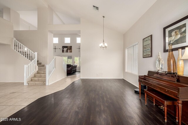 6971 W El Cortez Pl, Peoria, AZ 85383 - foyer featuring high vaulted ceiling, a chandelier, stairs, wood finished floors, and baseboards