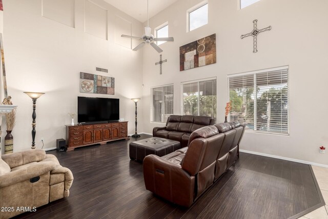 6971 W El Cortez Pl, Peoria, AZ 85383 - living area featuring a ceiling fan, dark wood-type flooring, healthy amount of natural light, a towering ceiling, and baseboards