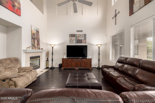 6971 W El Cortez Pl, Peoria, AZ 85383 - living room featuring a high ceiling, dark wood-style floors, ceiling fan, a fireplace, and baseboards