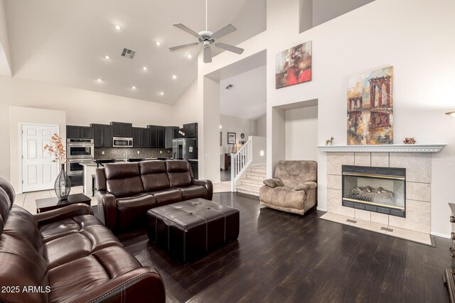 6971 W El Cortez Pl, Peoria, AZ 85383 - living room featuring high vaulted ceiling, wood finished floors, a ceiling fan, stairs, and a fireplace