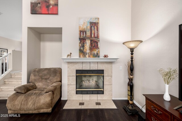 6971 W El Cortez Pl, Peoria, AZ 85383 - living area featuring wood finished floors, a tiled fireplace, baseboards, and stairway