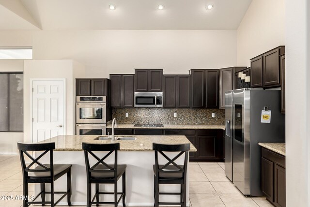 6971 W El Cortez Pl, Peoria, AZ 85383 - kitchen with stainless steel appliances, a sink, light tile patterned floors, backsplash, and recessed lighting