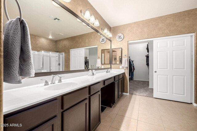 6971 W El Cortez Pl, Peoria, AZ 85383 - full bath with tile patterned flooring, double vanity, a shower stall, a spacious closet, and baseboards