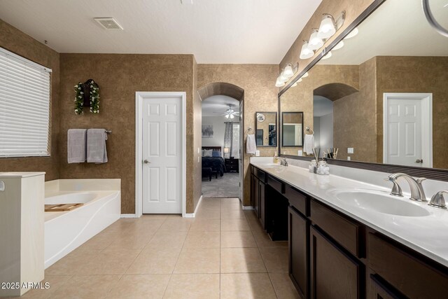 6971 W El Cortez Pl, Peoria, AZ 85383 - bathroom with double vanity, a bath, tile patterned floors, a ceiling fan, and ensuite bath