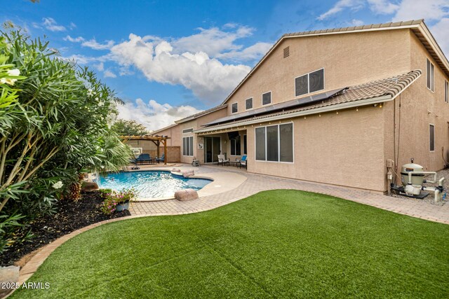 6971 W El Cortez Pl, Peoria, AZ 85383 - rear view of property featuring stucco siding, solar panels, a patio, and a yard
