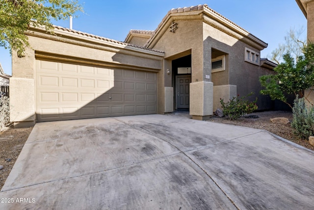 view of front facade with concrete driveway, stucco siding, and an attached garage